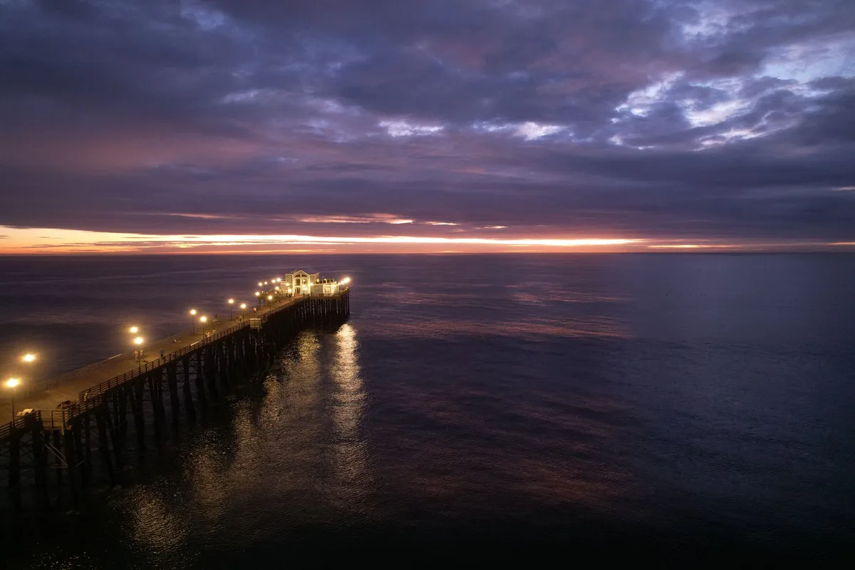 The Oceanside Pier lit up at sunset in Oceanside, California