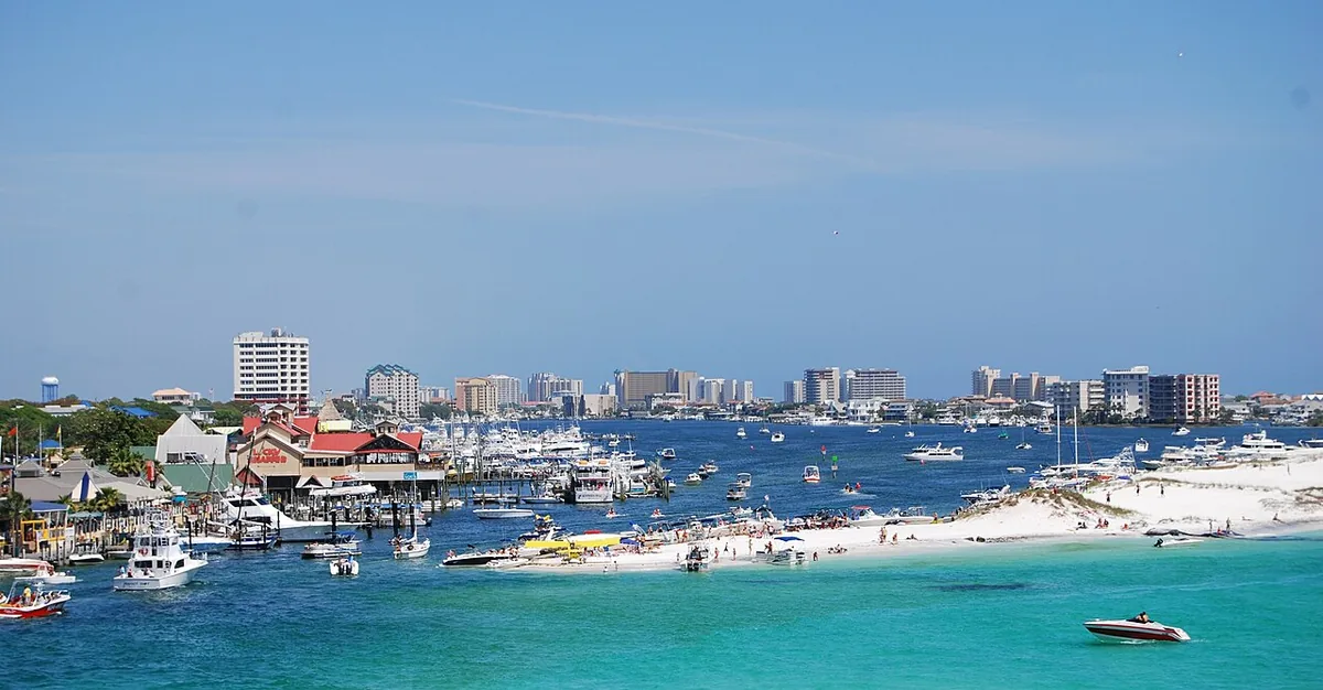 Destin Harbor crowded with boats beside white sand and emerald water
