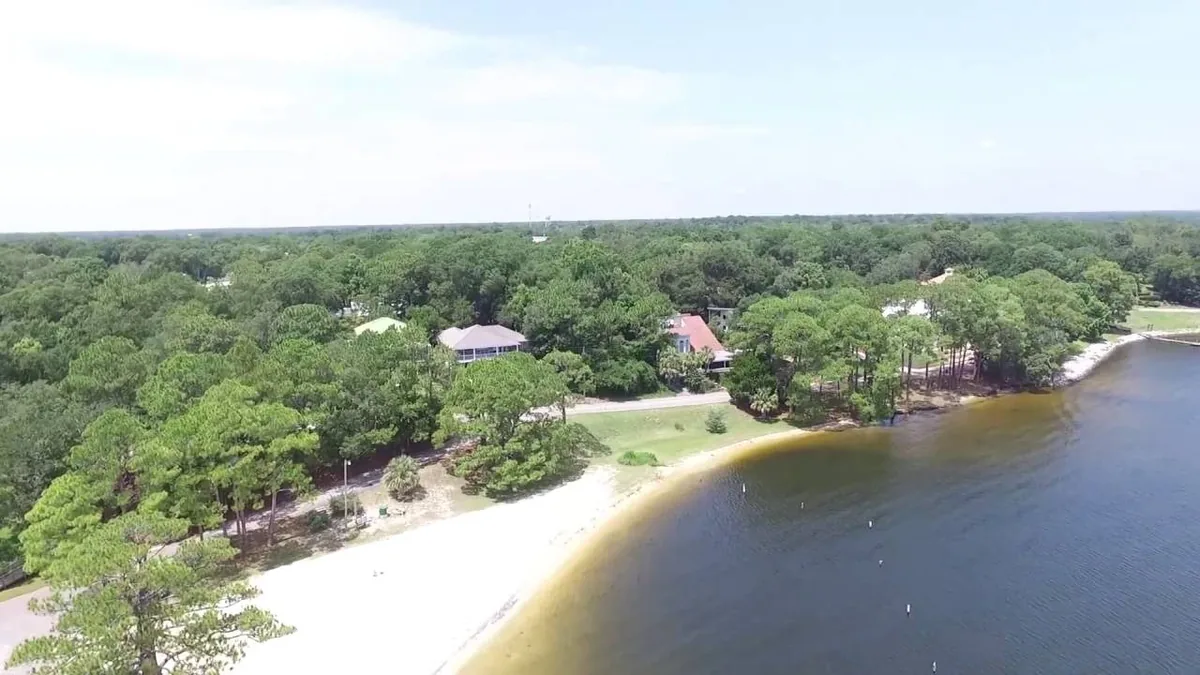 Aerial view of the Boggy Bayou shoreline with white sand and pines in Valparaiso and Niceville
