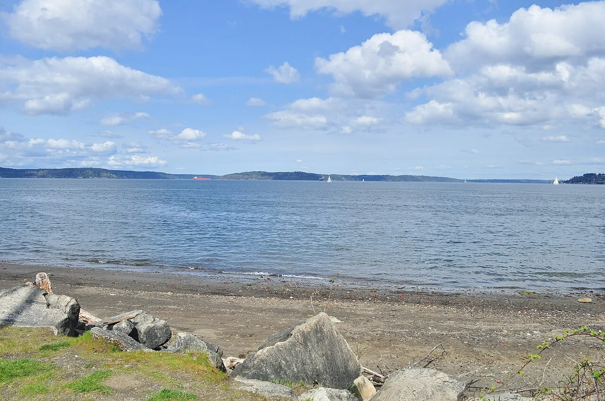 Looking north across Commencement Bay from the shoreline along Ruston Way in Tacoma, with sailboats on the water