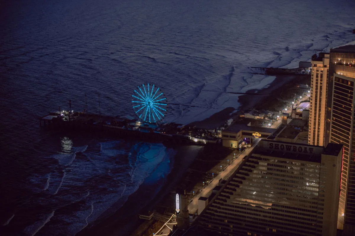 Atlantic City's illuminated Ferris wheel on the coast at night