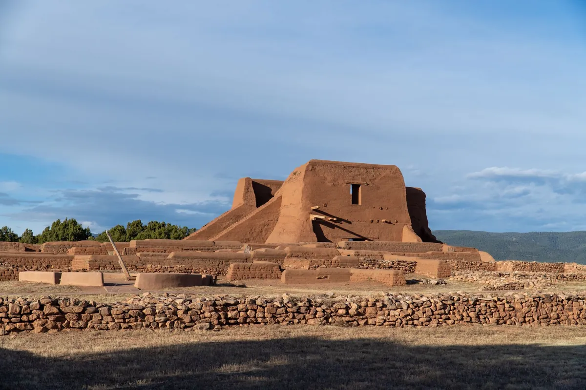 Adobe ruins under a bright blue sky at Pecos National Historical Park