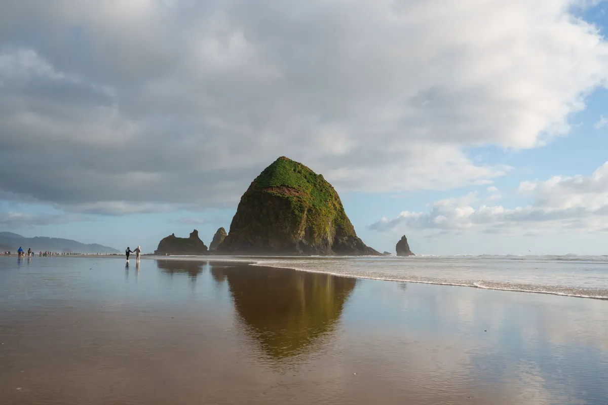 Haystack Rock reflected on the wet sand at Cannon Beach, Oregon